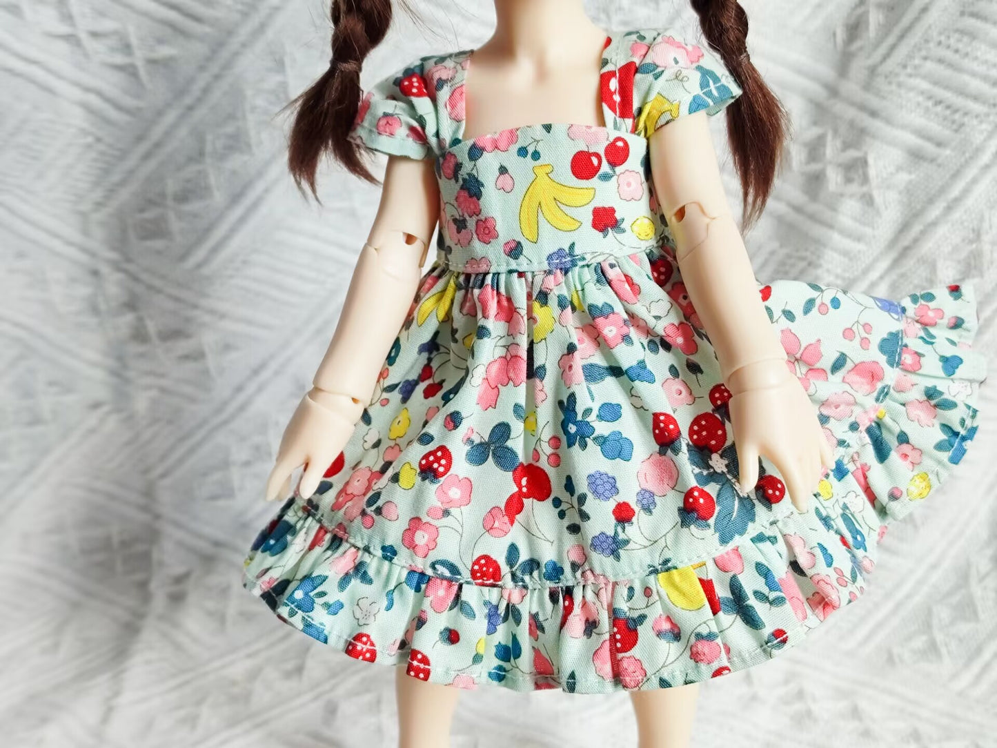 Close-up detail of 1/6 BJD YoSD doll clothes, vibrant floral and fruit pattern.