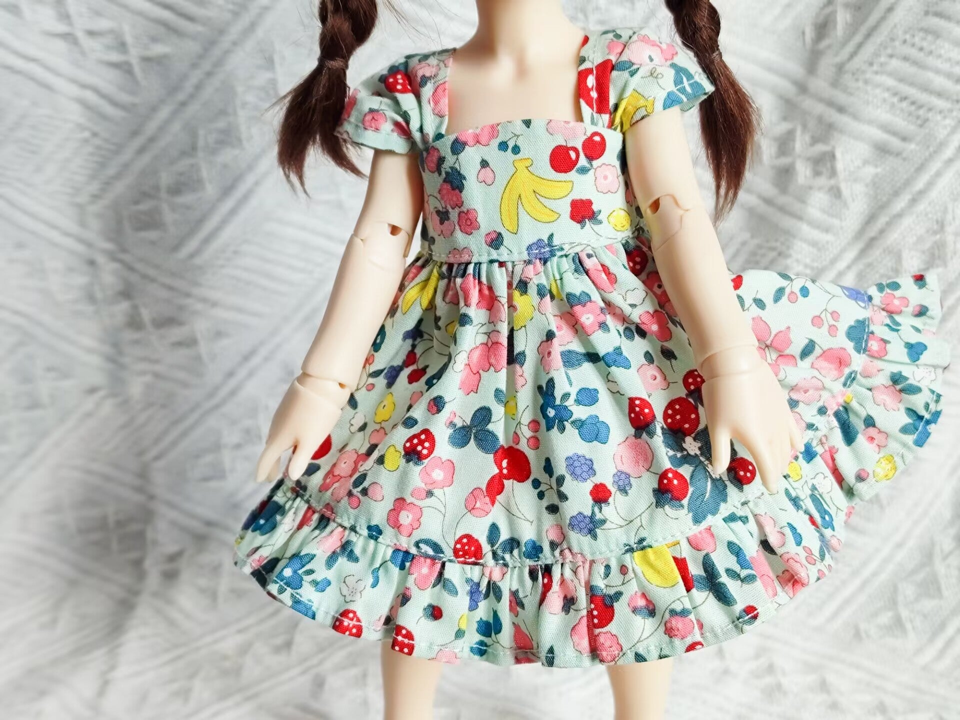 Close-up detail of 1/6 BJD YoSD doll clothes, vibrant floral and fruit pattern.