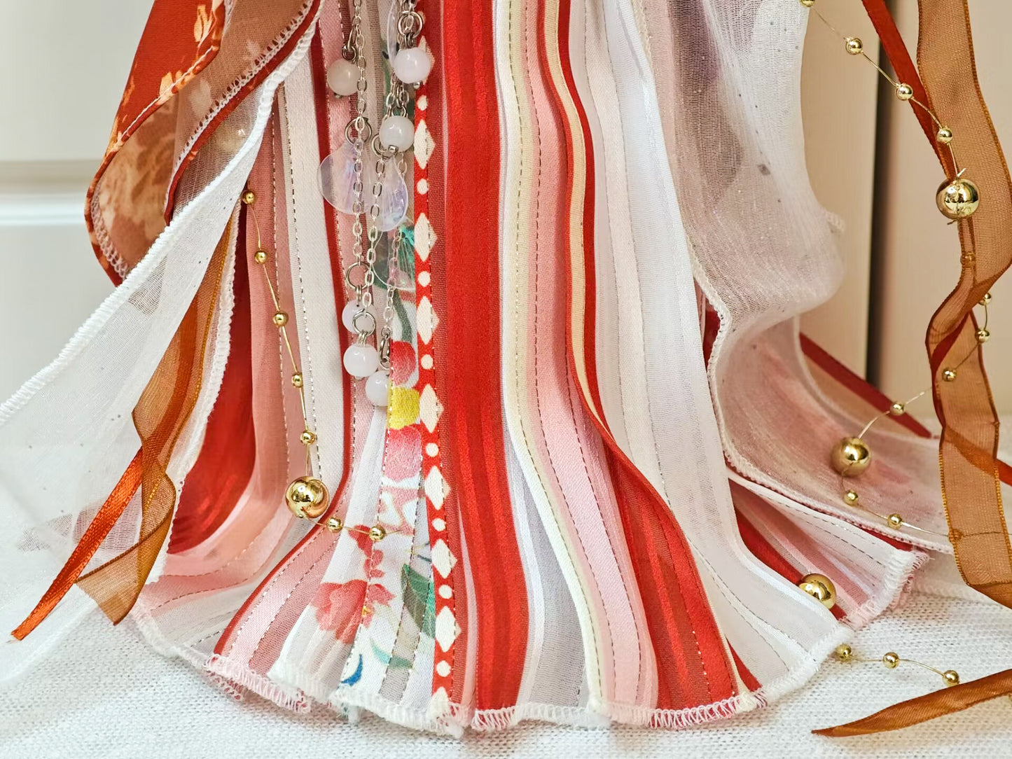 Close-up of 1/6 BJD YoSD doll clothes, organza cape and red Hanfu skirt texture details.