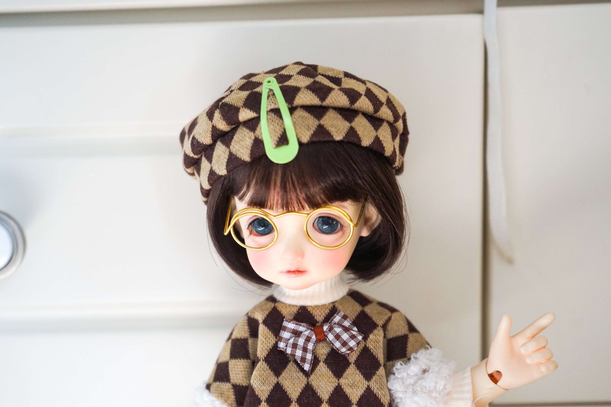 Upper body view of BJD doll wearing argyle vest, beret, and glasses.