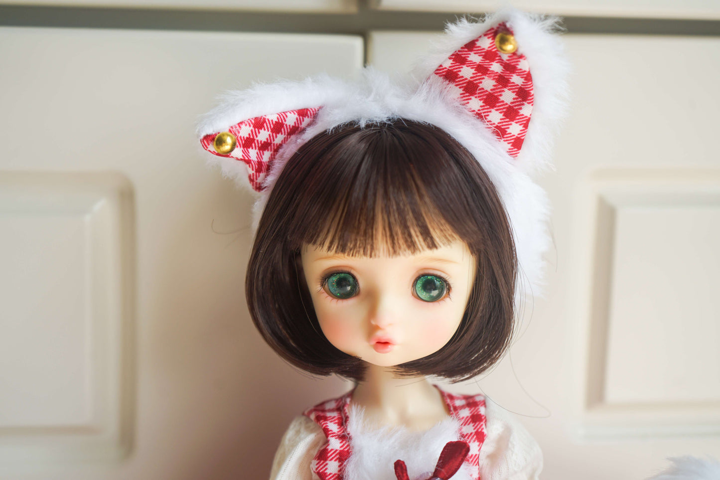 Close-up of handmade cat ears with gingham detail on a 1/6 BJD doll.
