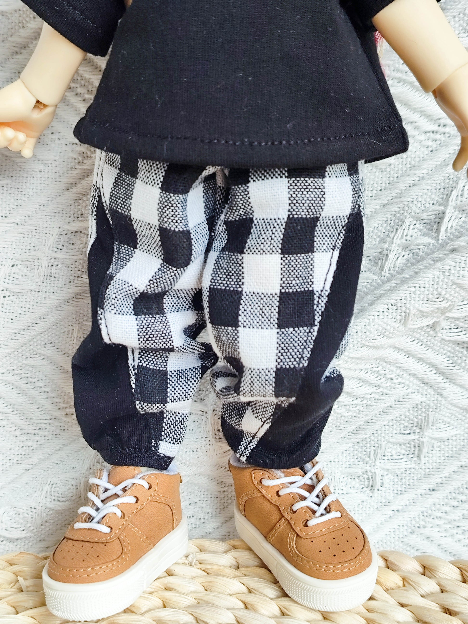 Close-up of the checkered pants and sneakers on a 1/6 BJD doll.