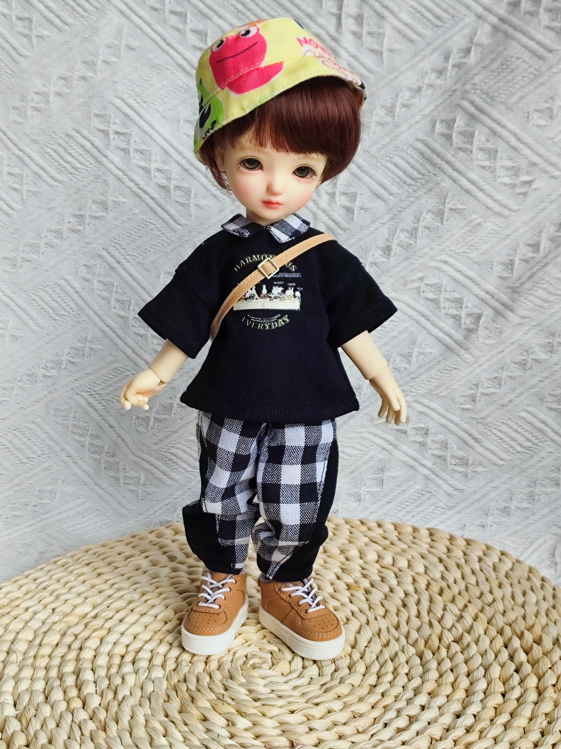 Front view of a 1/6 BJD YoSD doll wearing a black graphic t-shirt and checkered pants.