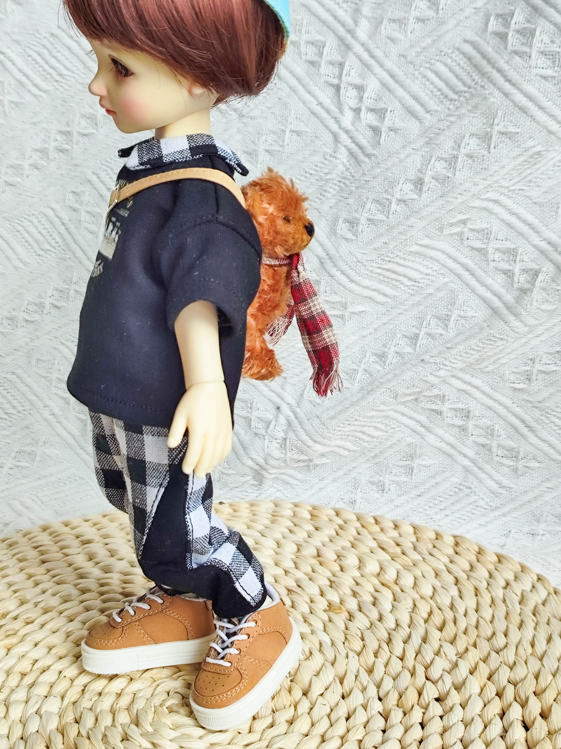 Side view of a 1/6 BJD doll showing the graphic t-shirt, checkered pants, and crossbody bag.