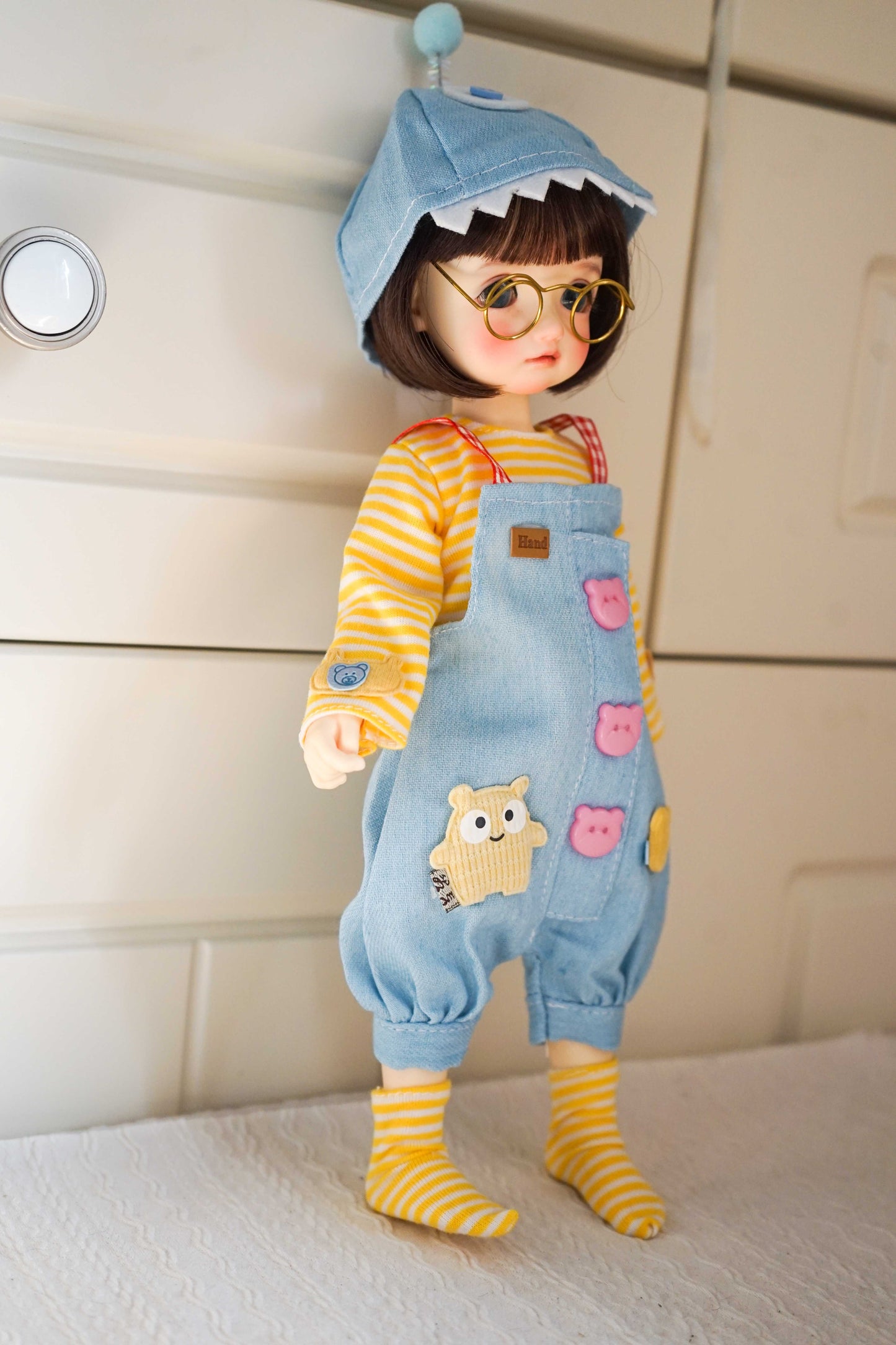 Side view of a 1/6 BJD YoSD doll showing the details of the shark hat and denim overalls.