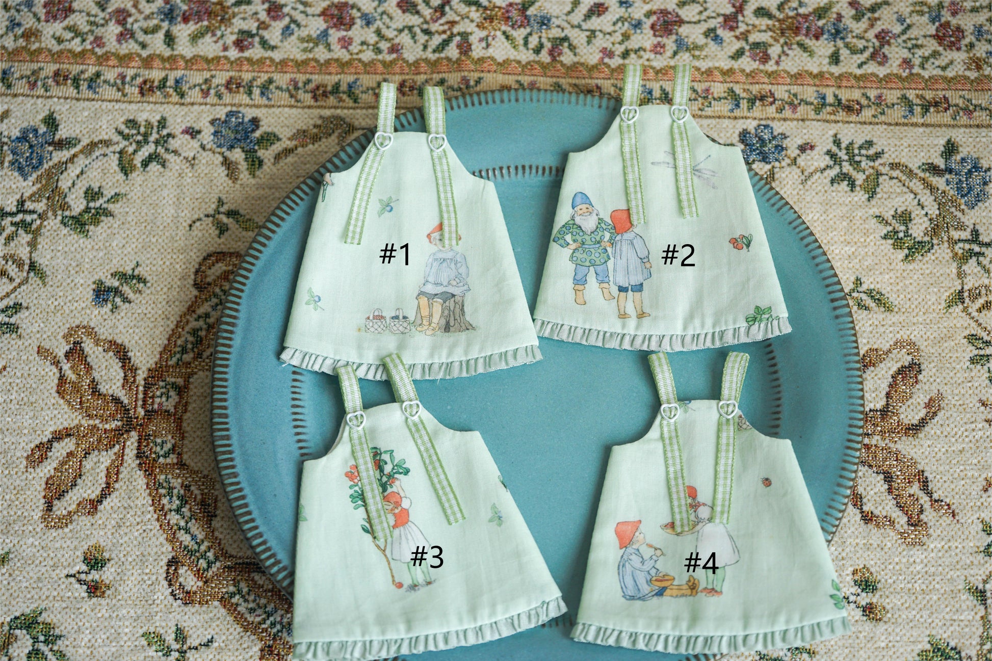 Flat lay collection of four handmade pastoral fairy tale pinafore dresses.