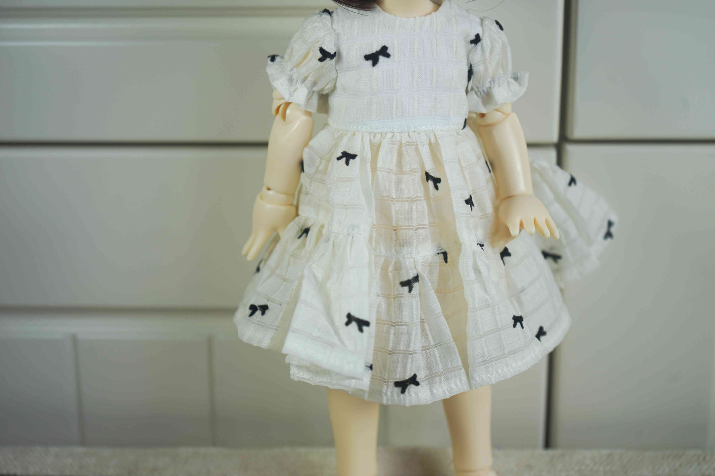 Close-up of the tiered skirt and bow print detail on the 1/6 BJD doll outfit.