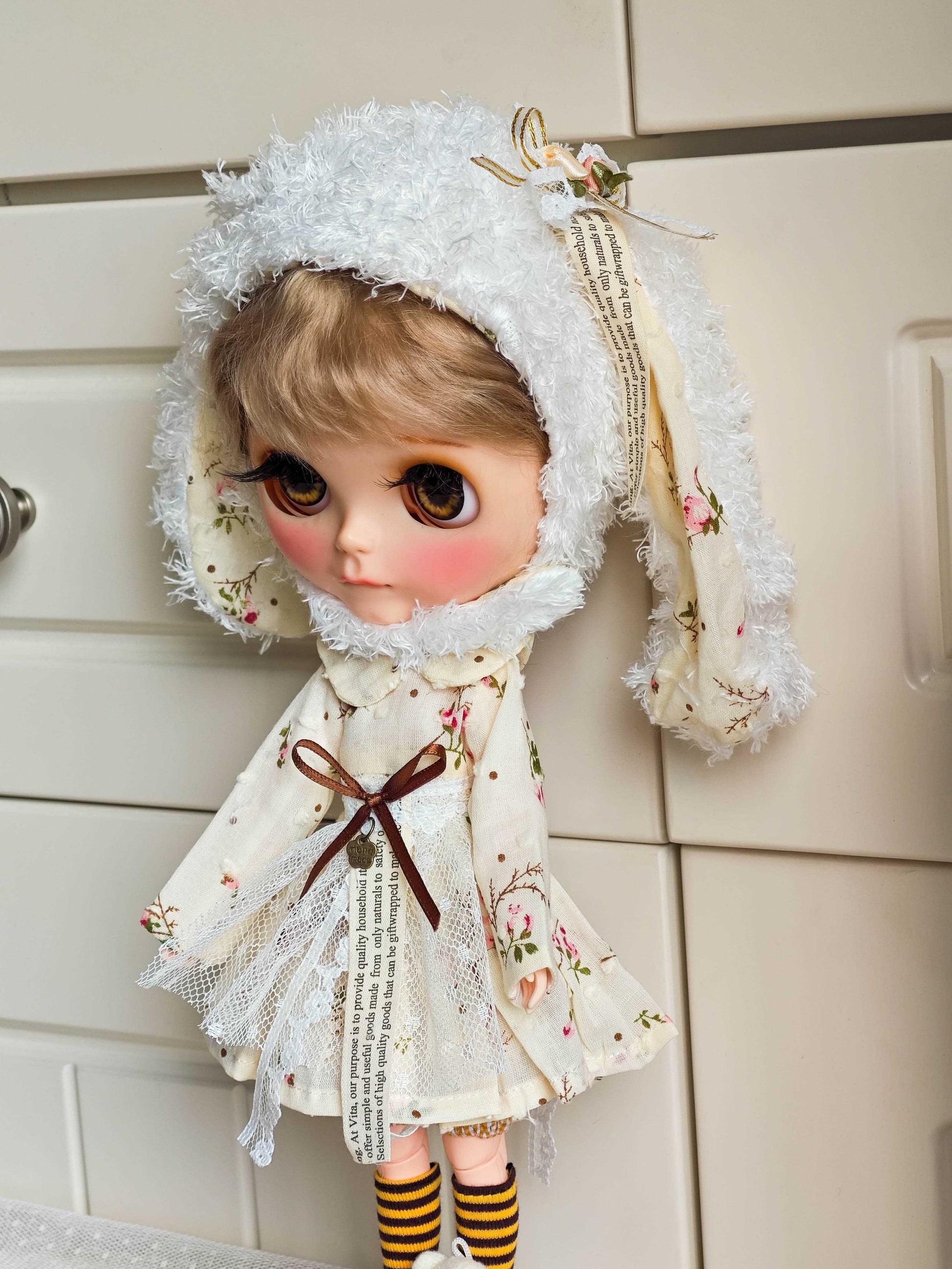 Side profile of the layered cottagecore style floral doll gown with white plush winter hat
