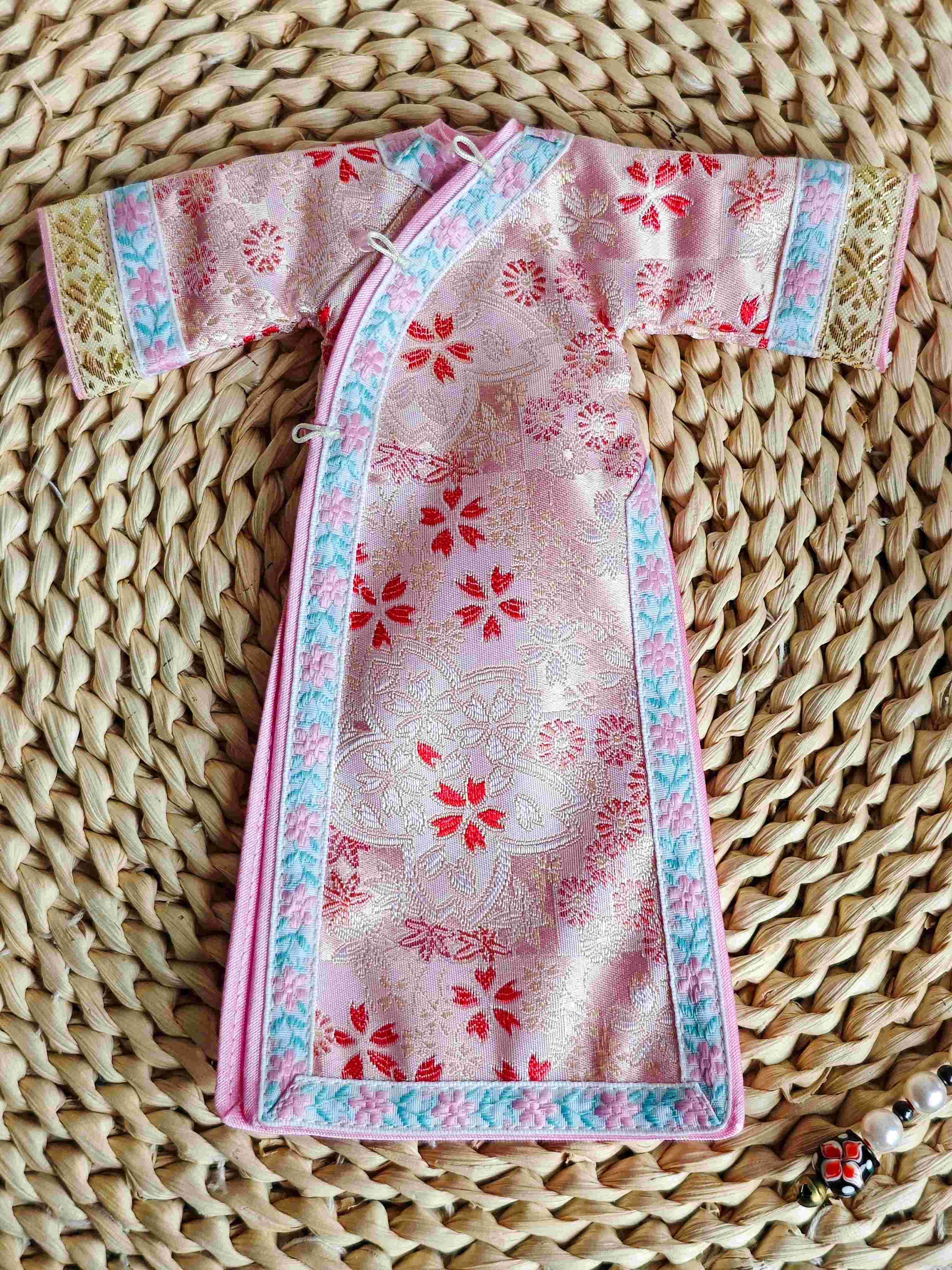 Flat lay product shot of the single piece miniature pastel pink brocade cheongsam dress.