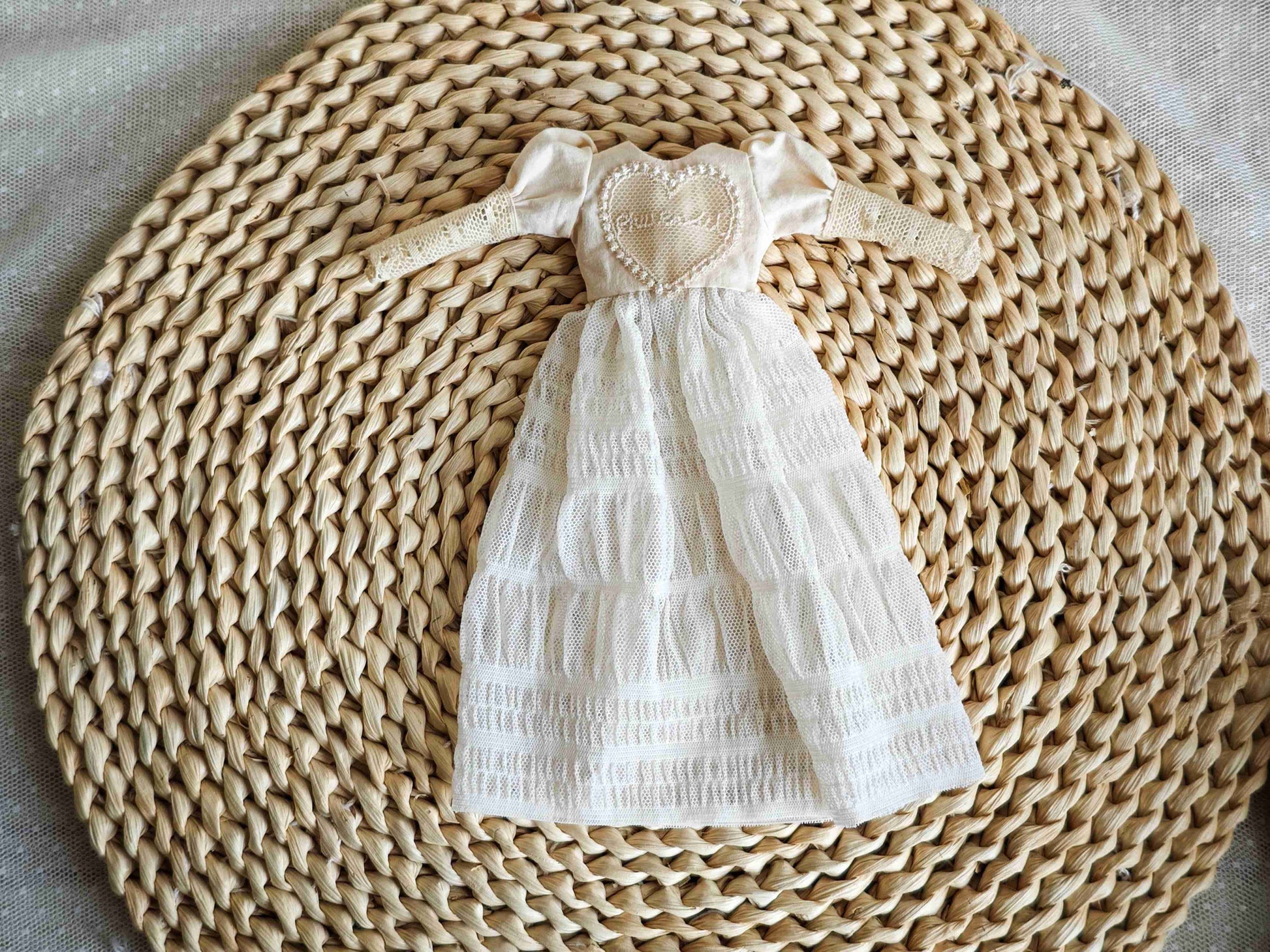 Flat lay details of the bodice and delicate lace stitching on the snowflake pattern vintage doll gown.