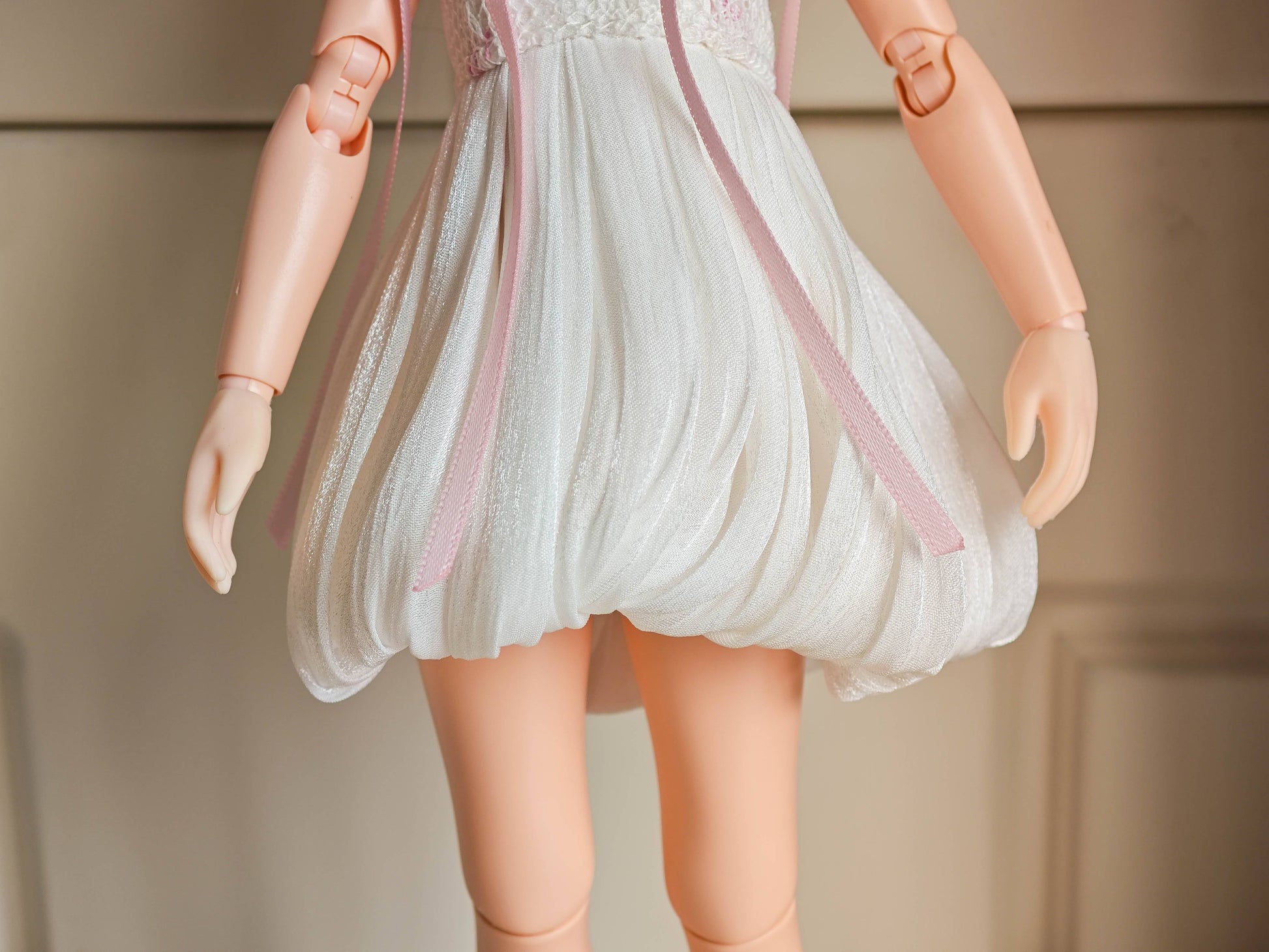 Flat lay product shot of the single piece coquette white pleated dress with pearl straps.