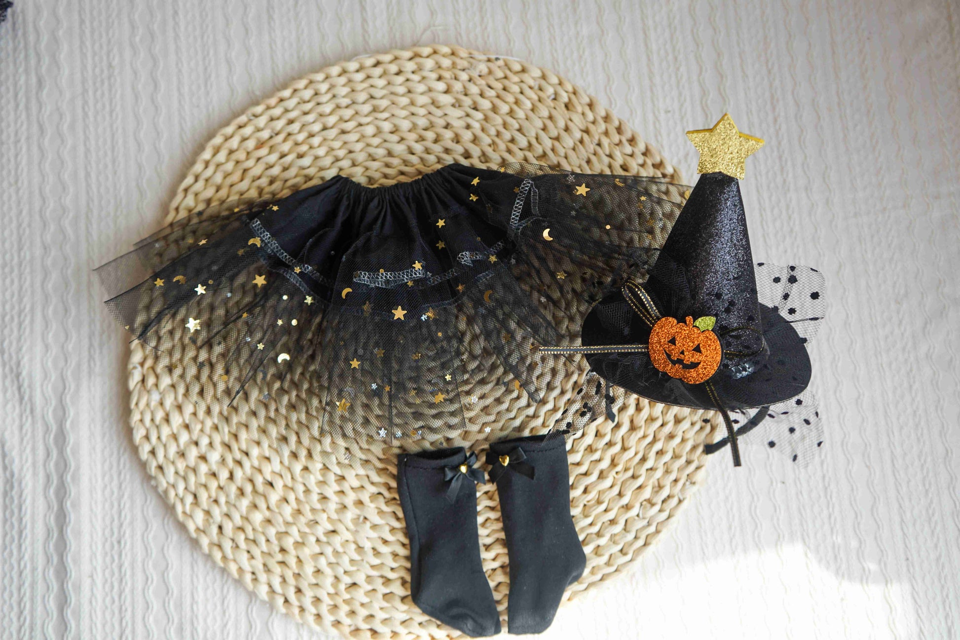 Flat lay display of the matching witch hat, petticoat, and striped socks for the 18-inch doll Halloween costume.