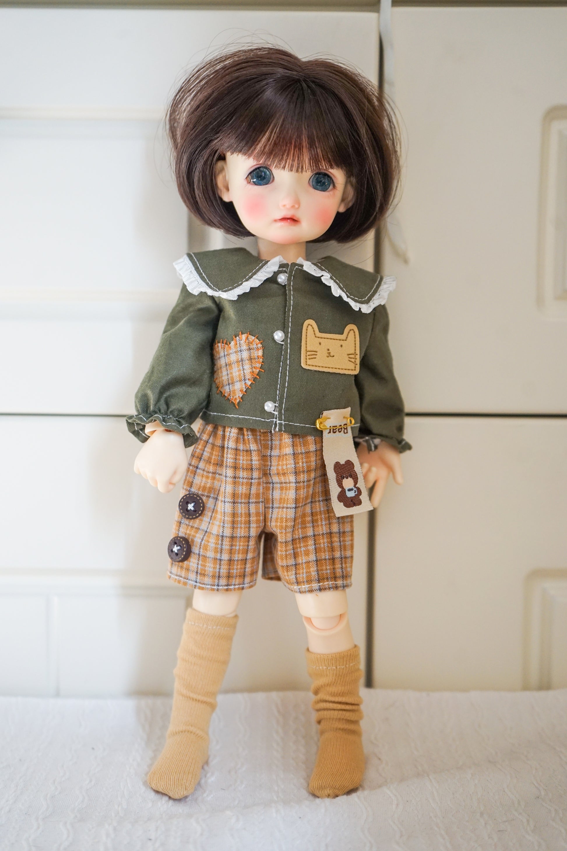 1/6 BJD YOSD doll wearing green cat patch shirt and plaid shorts.