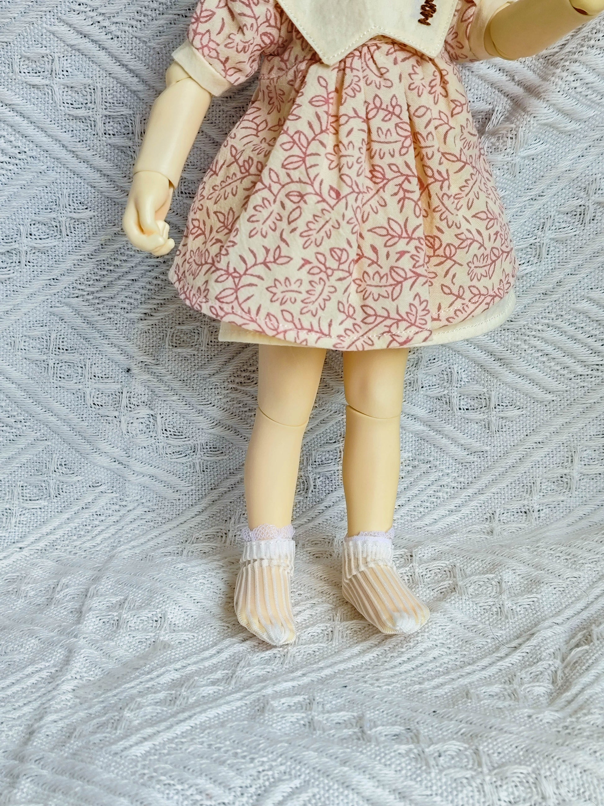 Close up of socks and details on leaf print doll outfit set.