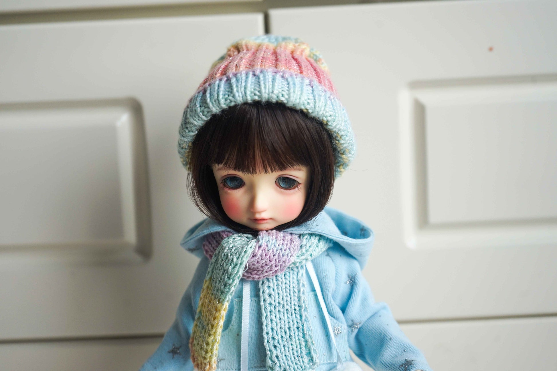 Upper body view of BJD doll wearing pastel snowflake knit hoodie.