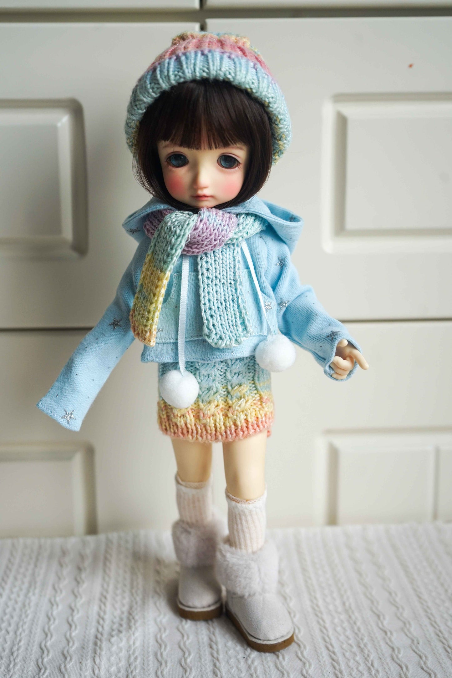 1/6 BJD YoSD doll wearing handmade pastel rainbow knit winter outfit.