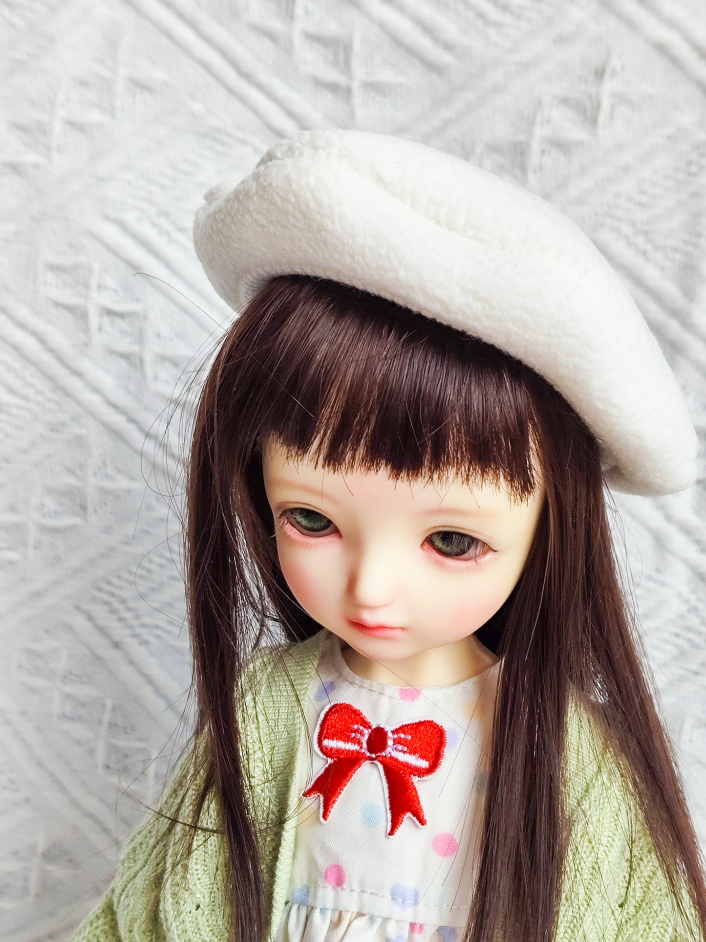 Close-up side view of doll outfit details including cardigan and dress.