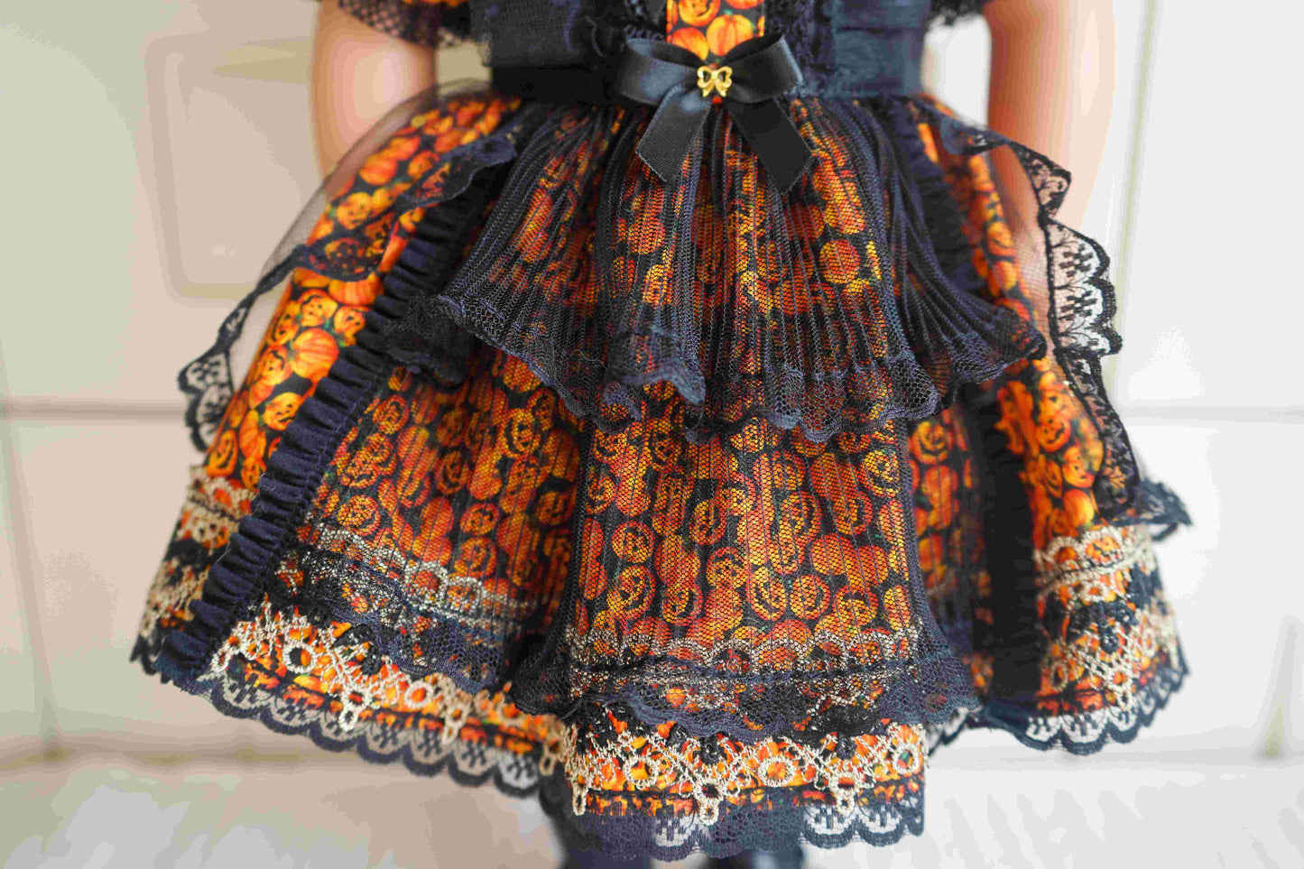 Detailed shot of the pumpkin print skirt of the witch doll costume.