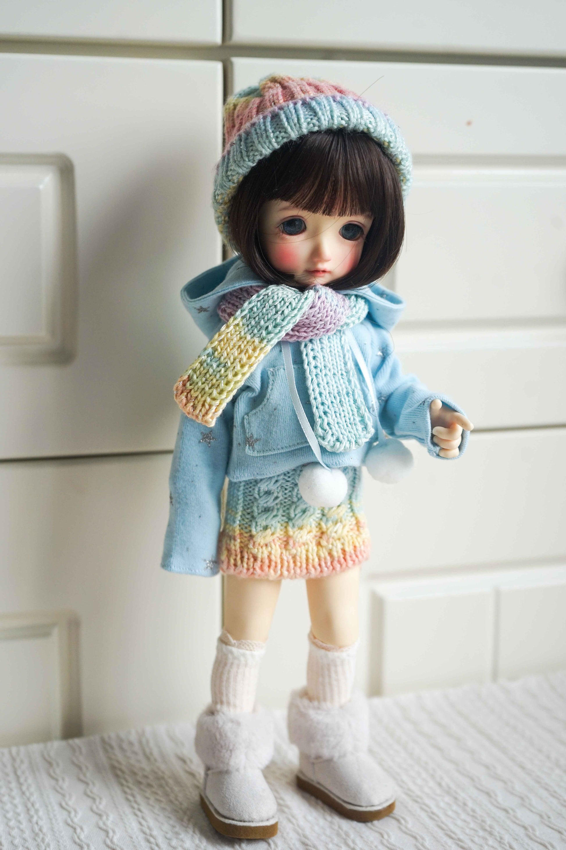 1/6 BJD YoSD doll wearing handmade pastel rainbow knit winter outfit.