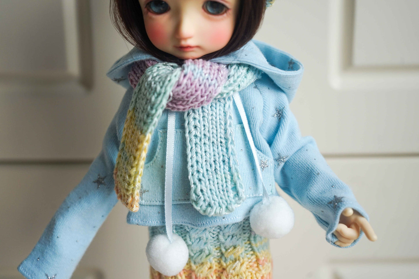 Close up of snowflake hoodie detail on handmade doll winter outfit.