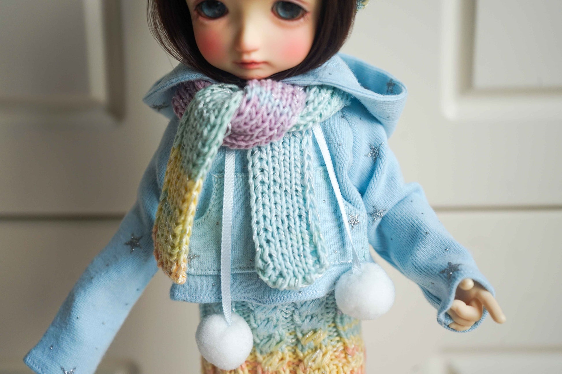 Close up of snowflake hoodie detail on handmade doll winter outfit.