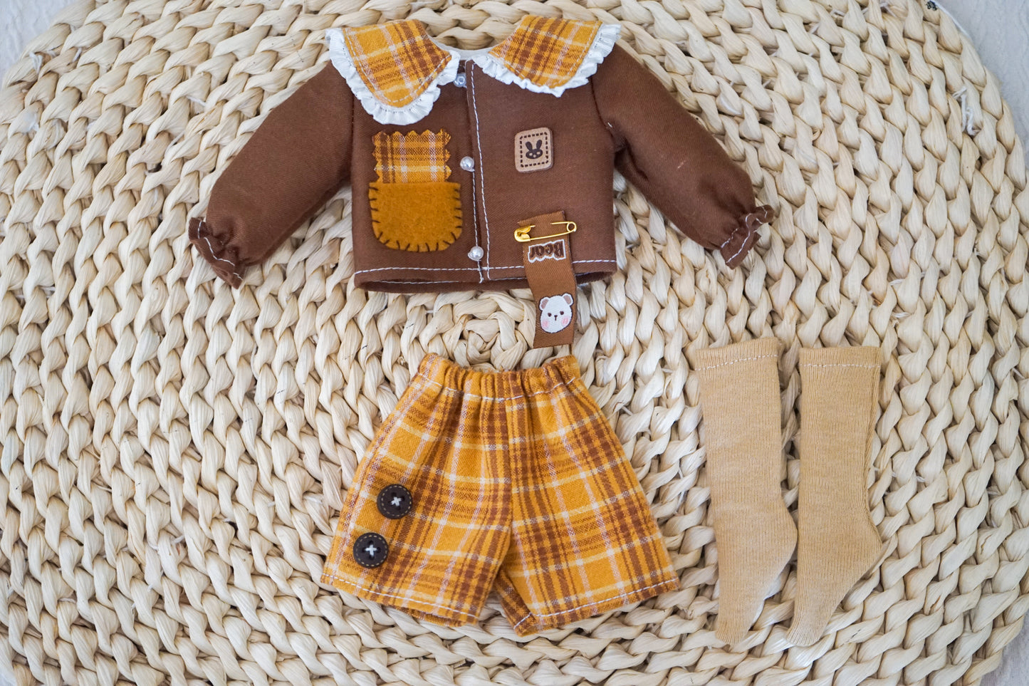 Product flat lay of the yellow cat patch shirt and plaid shorts.