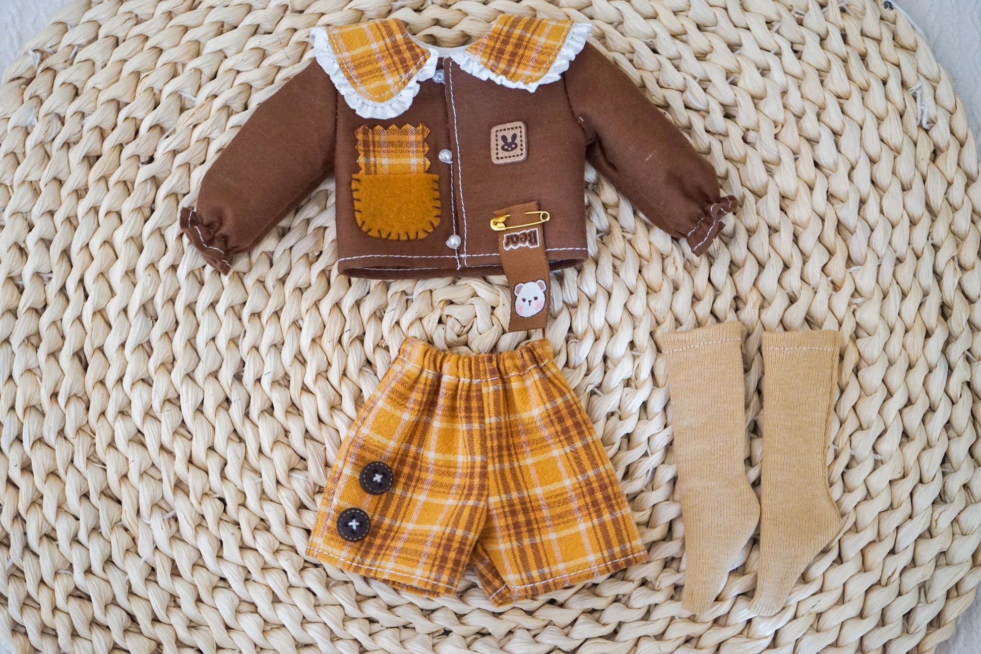 Product flat lay of the yellow cat patch shirt and plaid shorts.